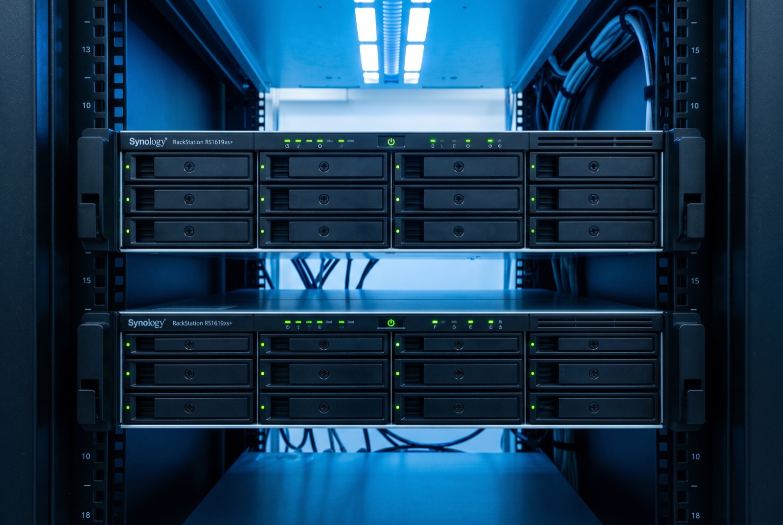 Two Synology RackStation NAS units mounted in a rack with blue accent lighting